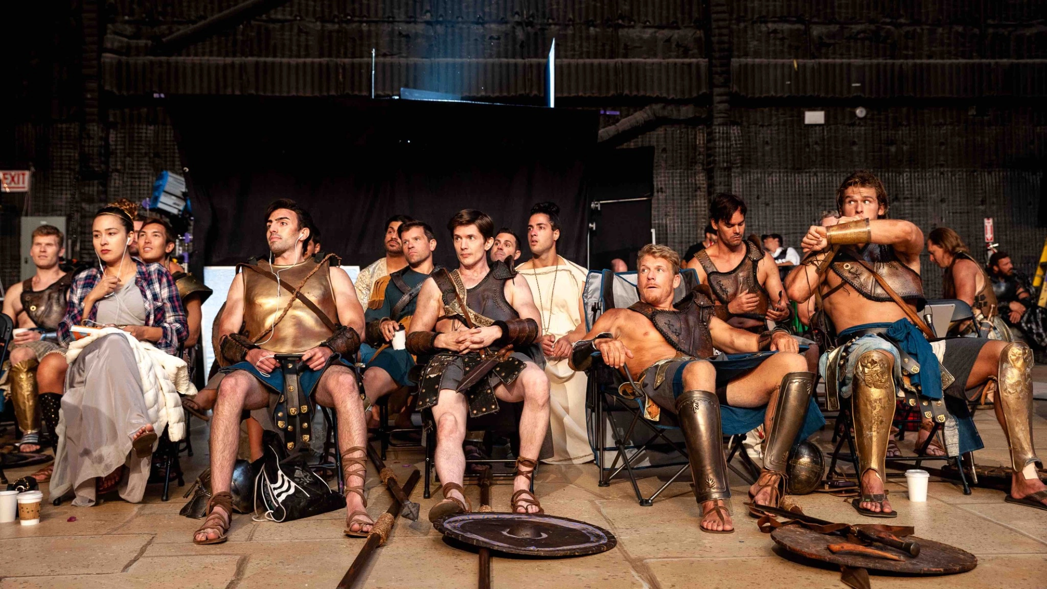 Performers in historical costumes seated on a film set